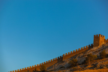 shot of a stone wall old ancient ruins on top of a hill in sunset light, Sudak, Crimea, Ukraine