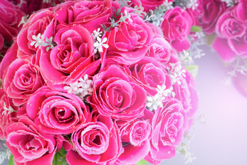 Pink floral background. Lot of artificial roses in colorful composition.