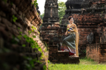 Beautiful women Thai girl holding hand lotus in traditional thai costume with temple ayutthaya,...