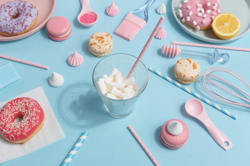 Kitchen utensils and tools, pastries and sweets on blue background. Top view. Copy space.