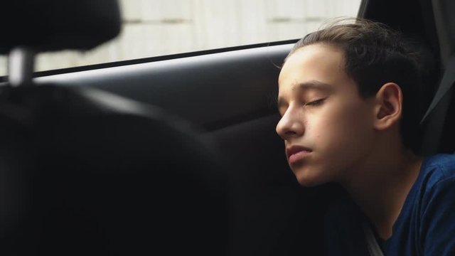 Close. Teenage Boy Sleeping In The Back Seat Of Car