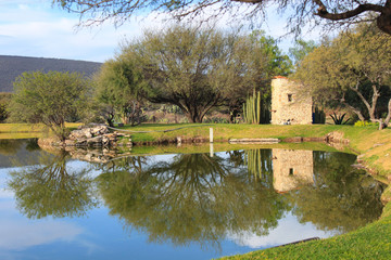 Fototapeta premium Paisaje de lago con reflejo de árboles y edificio de piedra