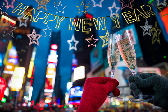 Happy New Year message hanging in sparkling silver banner with stars above romantic Champagne toast Times Square, New York City