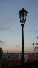 Prague, Czech Republic, a view over the city at sunset with a vintage iron lamp post in the foreground