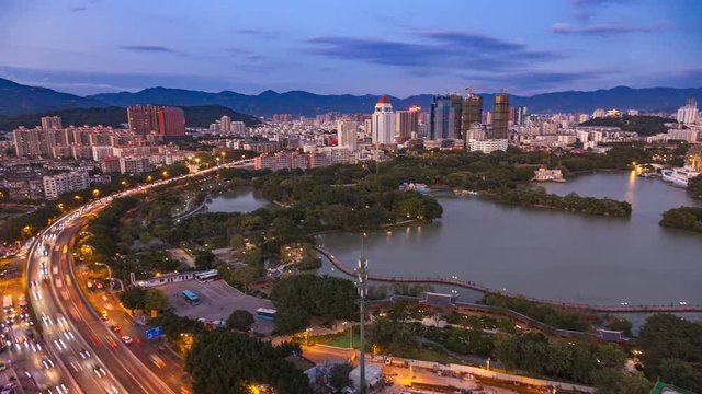 Beautiful cityscape at sunset.Scenic aerial view of highway  with dense traffic along the Xihu   lake,Fuzhou,Fujian,China. 4K time lapse, lens shift and zooming.