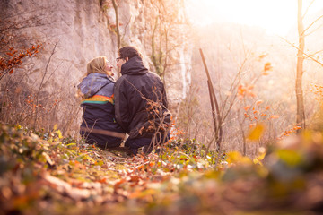 Loving couple enjoys the mountain view, beautiful scenery with sundown, autumn