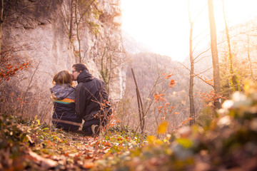Loving couple enjoys the mountain view, beautiful scenery with sundown, autumn