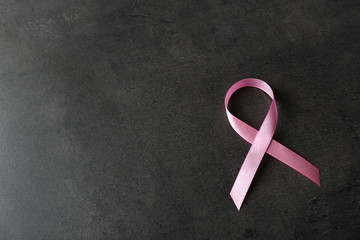 Pink ribbon and space for text on dark background. Breast cancer awareness concept