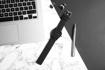 Flat lay composition with stylish wrist watch and laptop on marble background. Time management