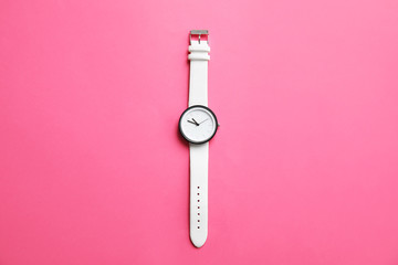 Stylish wrist watch on color background, top view. Fashion accessory