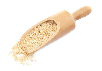 Scoop with raw unpolished rice on white background
