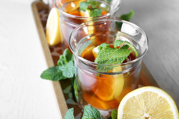 Wooden tray with hot tea in glasses on table, closeup