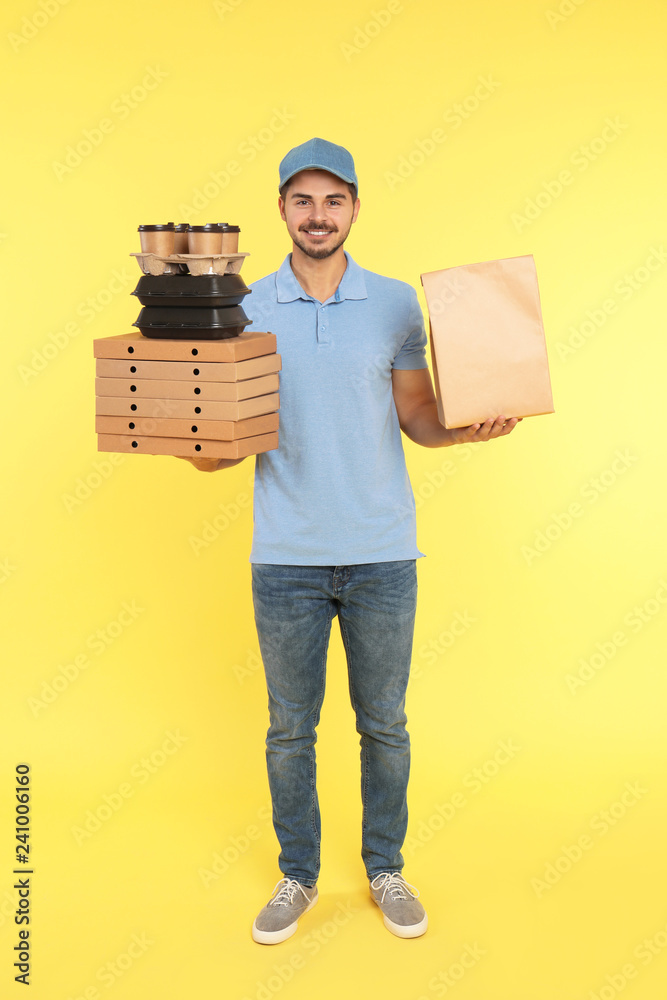 Canvas Prints Young courier with different orders on color background. Food delivery service