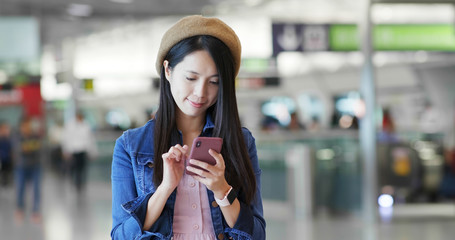 Fototapeta premium Woman use of mobile phone in the station