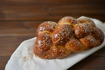 Traditional Jewish sweet Challah bread on a wood plate on wooden table / background with copy space