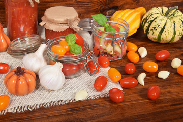 cocktail tomatoes, garlic, spices, colorful pumpkins and scattered kitchen salt, mortar for the winter
