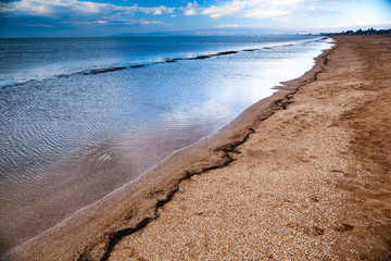dramatic scenery empty long sandy beach with shallow water and cloudy storm sky, Crimea, Ukraine