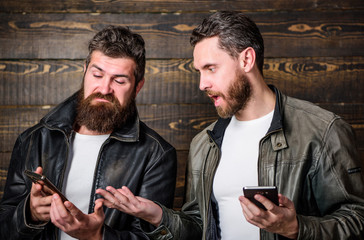 Men with smartphones surfing internet. Mobile internet. Business application. Men brutal bearded...