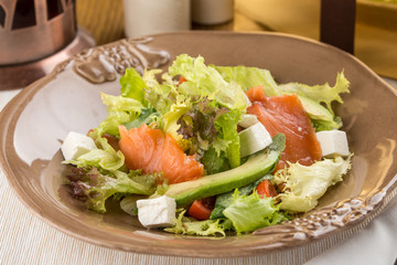 smoked salmon salad with fresh greens and feta cheese for breakfast on wooden table
