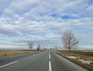 Fototapeta premium Couds on the highway - winter time - People traveling by car in a sunny winter day