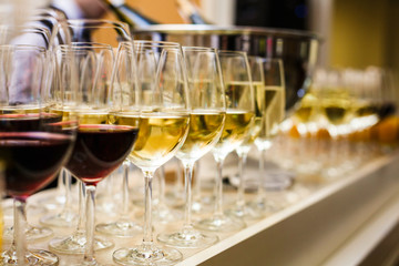 rows of wine glasses with red and white wine on a buffet table