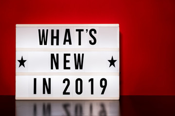 What's new in 2019 sign - cinema style lettering on light box & warm red background