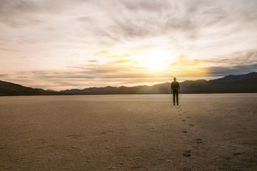 baroudeur regardant le coucher de soleil dans le désert