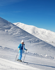 Fototapeta na wymiar Skier on snowy ski slope at nice sunny day