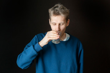 handsome young thirsty male drinking filtred water from glass b
