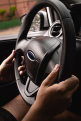 Selective focus man's hand on steering wheel, driving a car at sunset. Travel background