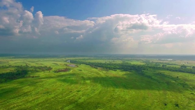 Aerial view of meadows, clouds over green meadows, Stunning aerial shot over lush green fields and meadows in the countryside, Shadows from clouds on green fields, Beautiful Landscape of Green Fields