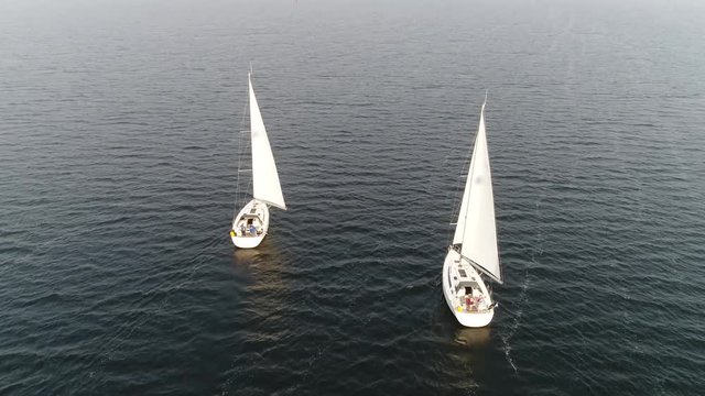 Aerial view of two sloop vessels are sailing boats with single mast one head sail and fore plus aft rig the most common configuration of modern sailboats is the Bermuda-rigged one 4k high resolution