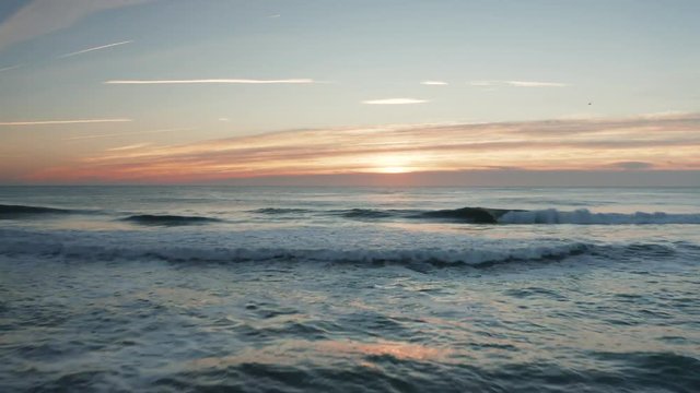 Soaring over the beach and ocean during a sunset 