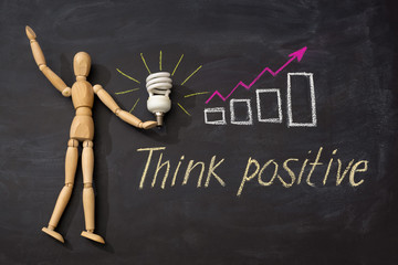 Light bulb on the background of drawn graphics with an arrow up and inscription Think positive
