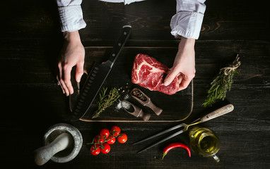 chef prepares rib-eye steak from a piece of fresh marbled beef