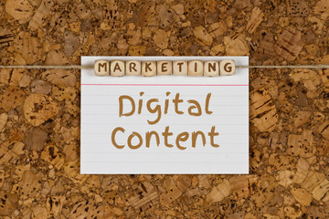 note with the words Marketing Digital Content attached to a cork pinboard