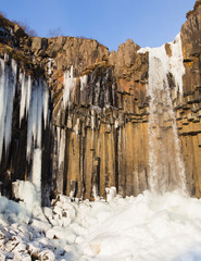 Fototapeta na wymiar Ice Stalactites at Svartifoss waterfall in winter time during a sunny day