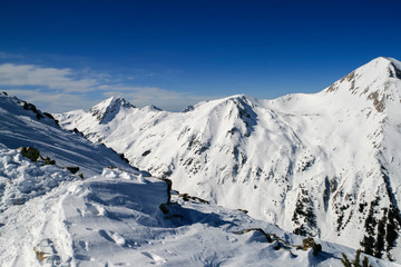 Obraz premium Winter landscape with hills covered with snow at Pirin Mountain, view from Todorka peak, Bulgaria