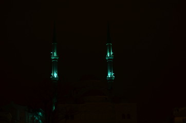 two minarets with green lights