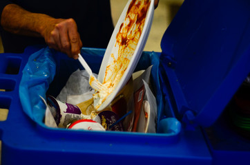 man pouring food waste into trash