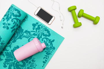 Fototapeta premium healthy lifestyle. Sport and healthy nutrition. Top view of sports equipment, dumbbells and yoga mat, sports water bottle and telephone. Flat lay with space for text