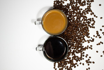 Aerial view of coffee mug with creamer and one black with coffee beans on half