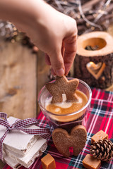 Gingerbread cookie in the female hand and aromatic fresh coffee. Holiday atmosphere and Christmas. Free space for text.