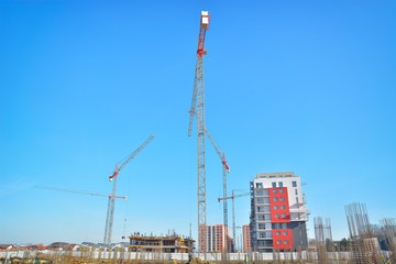 Building crane and building under construction against blue sky