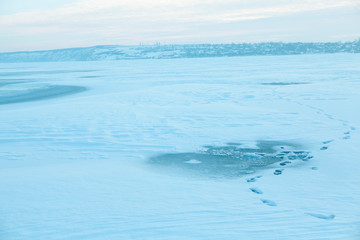 Naklejka na ściany i meble footprints on the frozen lake surface