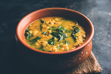 Dal Palak or Lentil spinach curry - popular Indian main course healthy recipe. served in a karahi/pan or bowl. selective focus