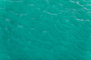Background shot of aqua sea water surface. Sea surface aerial view. Waving water surface of the sea background.