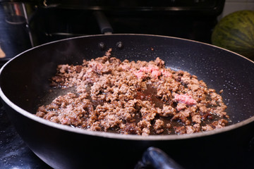Ground beef cooking in frying pan