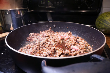 Ground beef cooking in frying pan