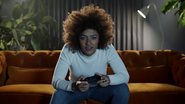 Determined young woman playing a video game with determination, skill and expertise..